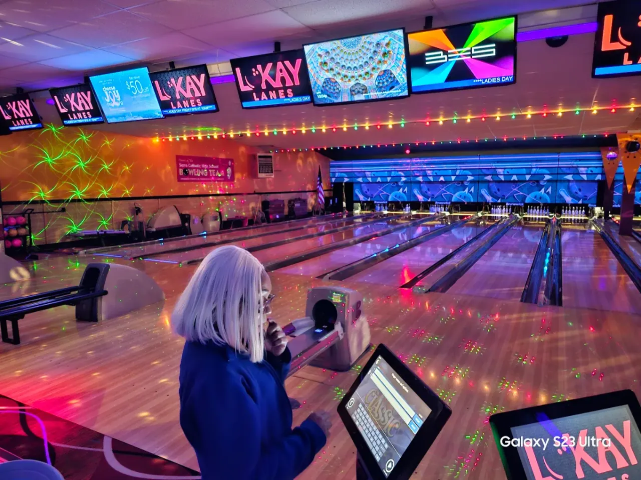 Cosmic glow bowling under blue and purple lights